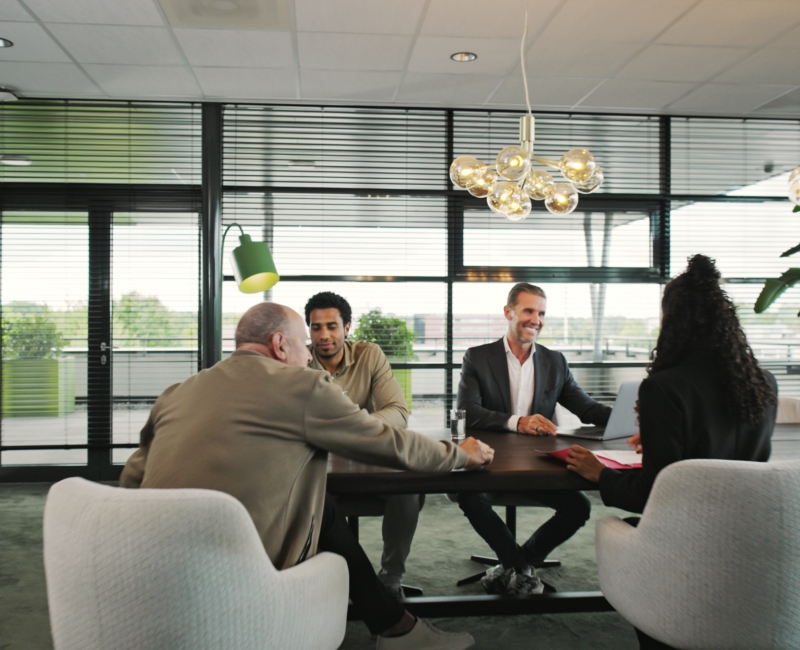Medewerkers van Please in overleg met een ondernemer