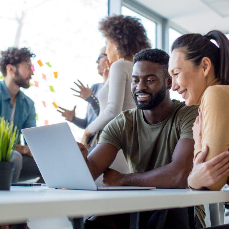 Flexwerkers bij elkaar op kantoor. Twee collega's bespreken iets op de computer | Flexwerkers